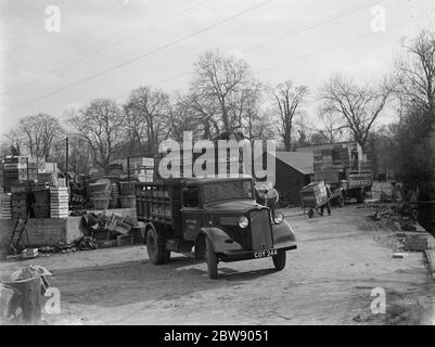 Lavoratori che caricano casse di legno su un camion Bedford appartenente a e James e Son , la grezza d'acqua e i coltivatori di insalate di Mitcham , Londra . 1937 Foto Stock