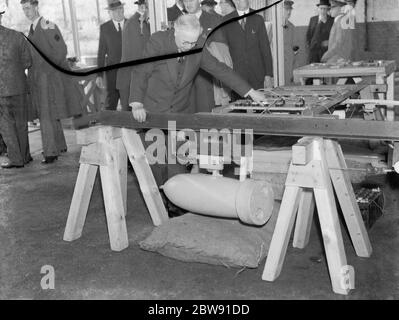 Sir Howard Kingsley Wood il Segretario di Stato per l'aria in visita alla fabbrica Vickers a Crayford, Kent . Sir Kingsley guarda su un meccanismo di rilascio della bomba . 1939 Foto Stock