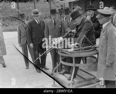 Sir Howard Kingsley Wood , Segretario di Stato per l' aria , in visita alla fabbrica Vickers di Crayford , Kent . Sir Kingsley tiene il grilletto della pistola a macchina bicomontata Vickers K-GO . 1939 Foto Stock