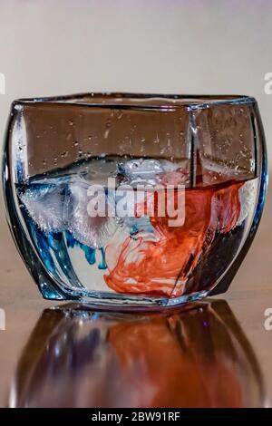 acqua con colorante rosso e blu nel recipiente in cristallo Foto Stock