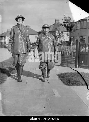 La donna più alta RAID Warden , Miss B Allnut , camminando lungo la strada con un collega Warden , MR G A Boys . Si trova a 6ft 2ins . 1939 Foto Stock