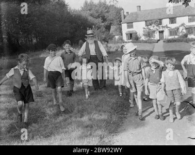 Bambini evacuati a Wye , Kent , camminando lungo una strada di campagna . 1939 Foto Stock