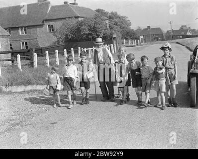 Bambini evacuati a Wye , Kent , camminando lungo una strada di campagna . 1939 Foto Stock