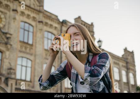 Giovane donna turistica scattare foto su fotocamera retrò. Ritratto di fotografo professionista Foto Stock