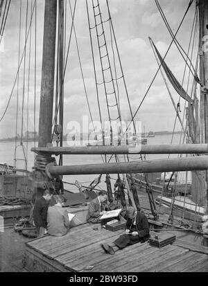 Gli studenti della scuola d'arte si siedono sul ponte di una Thames Barge disegnando immagini a Gravesend , Kent . 1939 Foto Stock