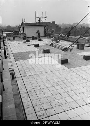 Lavoratori della Val De Travers Asphalt Limited , una società di pavimentazione , che lavorano alla pavimentazione del tetto del London Jewish Hospital di Steppey Green . 1938 Foto Stock