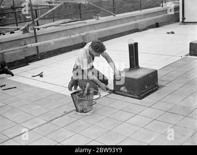 Lavoratori della Val De Travers Asphalt Limited , una società di pavimentazione , che lavorano alla pavimentazione del tetto del London Jewish Hospital di Steppey Green . 1938 Foto Stock