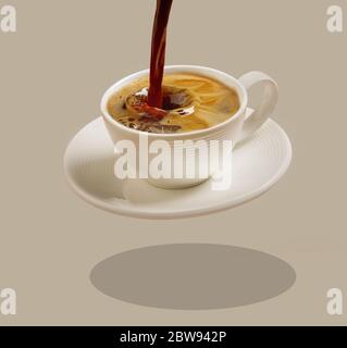 tazza di caffè che si levita su sfondo marrone Foto Stock