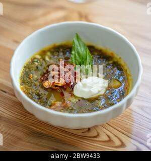 ciotola di zuppa di sorbetto con pancetta e panna acida su tavolo di legno Foto Stock