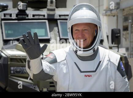 In questa foto rilasciata dalla National Aeronautics and Space Administration (NASA), l'astronauta della NASA Douglas Hurley si fa balzare mentre lui e il suo compagno di equipaggio Robert Behnken escono dal Neil A. Armstrong Operations and Checkout Building per il complesso di lancio 39A a bordo della navicella spaziale SpaceX Crew Dragon per il lancio della missione Demo-2, Sabato 30 maggio 2020, presso il Kennedy Space Center della NASA in Florida. La missione SpaceX Demo-2 della NASA è il primo lancio con astronauti della navicella spaziale SpaceX Crew Dragon e Falcon 9 alla Stazione spaziale Internazionale come parte del programma Commercial Crew dell'agenzia. Il Foto Stock