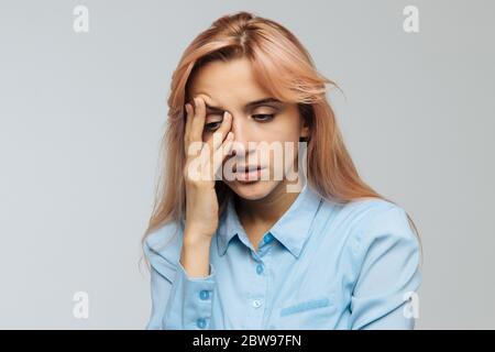 Donna dispiaciuta quasi addormentarsi al lavoro, tenere la testa con hand.Sleepy studente trascorrere il tempo in università, si sente la mancanza di energia. Sonno senza Foto Stock