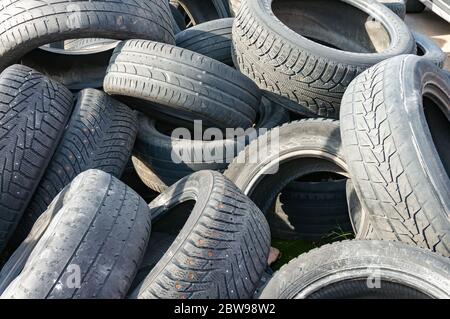 Un mucchio di vecchi pneumatici usati di gomma per auto di protezione al servizio o scarico con rifiuti e rifiuti pronti per il riciclaggio: San Pietroburgo, Russia, maggio 2020 Foto Stock