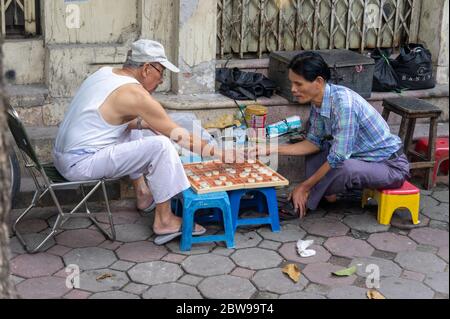 Hanoi, Vietnam - 21 ottobre 2019. Scena di strada, due uomini giocano a scacchi cinesi (xiangqi) Foto Stock