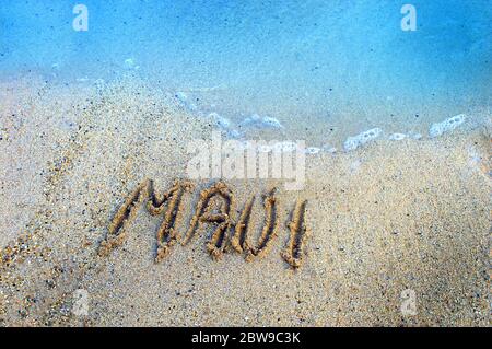 Le lettere disegnate con le dita resistono al leggero riflusso e al flusso delle acque dell'Oceano Pacifico che circondano le isole hawaiane. Maui detiene il suo io Foto Stock