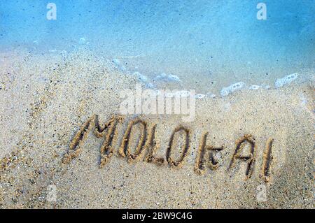 Le lettere disegnate con le dita resistono al leggero riflusso e al flusso delle acque dell'Oceano Pacifico che circondano le isole hawaiane. Molokaii tiene la sua o Foto Stock