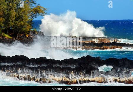 La grande ondata colpisce la costa nera di lava del Mackenzie state Park sulla Big Island delle Hawaii. Foto Stock