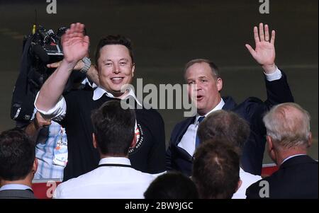 Il CEO di SpaceX, Elon Musk (a sinistra) e l'amministratore della NASA, Jim Bridenstine, si sono fatti un'onda al pubblico dopo il lancio di un razzo Falcon 9 con la navicella spaziale Crew Dragon da PAD 39A al Kennedy Space Center durante un evento post lancio presso il Vehicle Assembly Building della NASA con il presidente degli Stati Uniti Donald Trump e il Vicepresidente Mike Pence. Gli astronauti della NASA Doug Hurley e Bob Behnken si rendezvous e attracceranno con la Stazione spaziale Internazionale, diventando la prima gente a lanciare nello spazio dal suolo americano dalla fine del programma di navetta spaziale nel 2011. Foto Stock