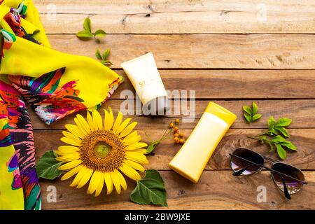 crema solare spf50 cosmetici cura della salute per la pelle viso con lozione corpo, sciarpa, occhiali da sole di stile di vita donna e girasole fiore giallo di stile di vita Foto Stock