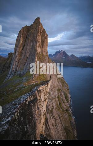 Norvegia, Senja, uomo in piedi sul bordo della scogliera nearÂ SeglaÂ montagna Foto Stock