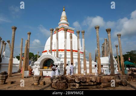 I pellegrini buddisti pregano al Thuparama Dagoba ad Anuradhapura. È il più antico dagoba dello Sri Lanka ed è stato costruito da Devanampiya Tissa. Foto Stock