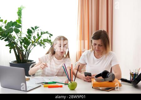 Madre e figlia si divertono durante l'apprendimento a distanza a casa Foto Stock