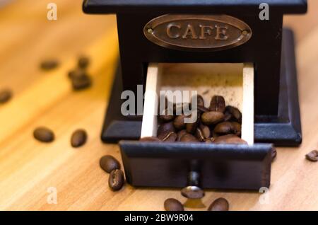 Un cassetto da un macinacaffè con metà della sua capacità piena di chicchi di caffè. Foto Stock