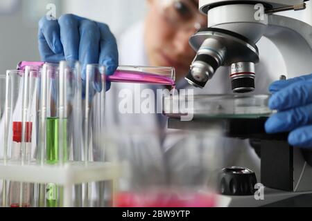 L'assistente di laboratorio versa il liquido per l'esame Foto Stock