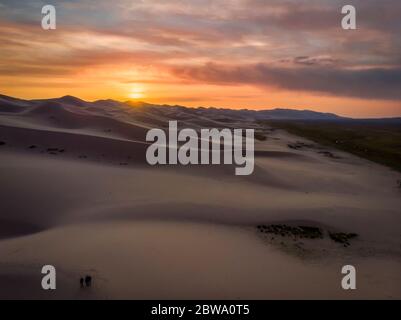 Tre persone a Singing Sand Dunes a Khongoryn Els, Gobi Gurvasaikhan National Park, Gobi Desert, Mongolia, Mongolia, Asia, Asiatico. Foto Stock
