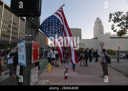 Los Angeles, Stati Uniti. 27 maggio 2020. Una bandiera americana strappata è appesa a una luce di strada mentre i dimostranti nel centro di Los Angeles protestano contro la morte di George Floyd, mercoledì 27 maggio 2020. Floyd, un uomo nero morto nella custodia della polizia di Minneapolis il 25 maggio. (Dylan Stewart/immagine dello sport) (Foto di IOS/Espa-Images) Credit: Agenzia europea per la fotografia sportiva/Alamy Live News Foto Stock