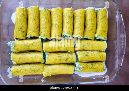 Preparazione fatta in casa di cannelloni tipici italiani con ricotta e spinaci. Sono completamente vegetariani. Foto Stock