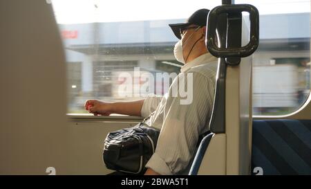 Un autista dell'autobus che indossa una maschera che aspetta l'orario di partenza Foto Stock