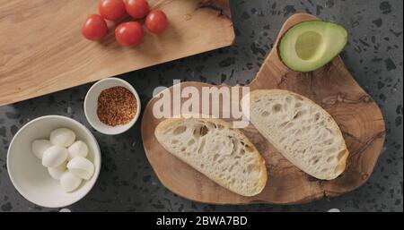 Vista dall'alto fette di pane ciabatta sul piano di cemento per la preparazione aprire i panini Foto Stock