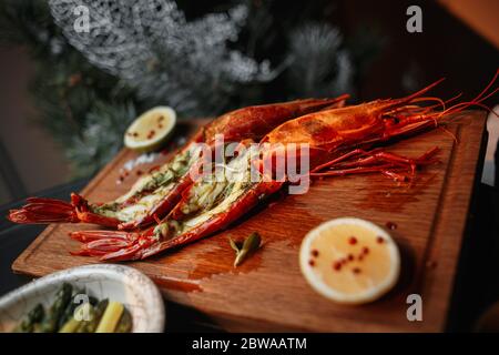 Langustins con lime e limone su una tavola boscosa Foto Stock