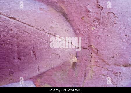 Viola astratto vernice su una parete bianca spaccata. Primo piano di una texture graffiti. Street art background. Foto Stock