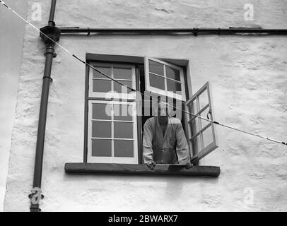 Il signor Compton Mackenzie si affaccia dalla finestra della sua casa sull'isola di Jethou, Isole del canale. 1927 Foto Stock