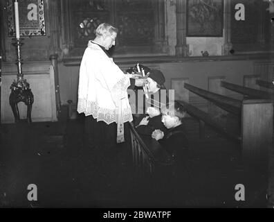 La benedizione di San Biagio , la cerimonia del candelino nella Chiesa di Sant' Etheldreda , Holborn , Londra . Padre Rob che conduce la cerimonia il 2 febbraio 1933 Foto Stock