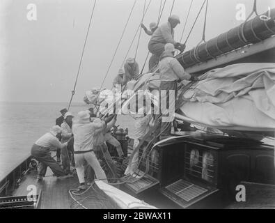 Il Kings Yacht' Britannia in gara a Cowes sull'isola di Wight , della costa meridionale dell'Inghilterra l'equipaggio che prepara la vela principale 2 agosto 1921 Foto Stock