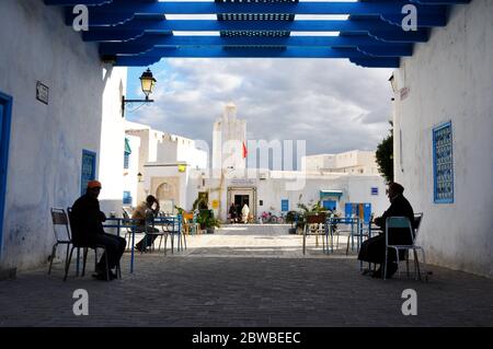 Scena di strada della vita quotidiana con la gente che si riunisce in una piazza a Kairouan, Tunisia. Foto Stock