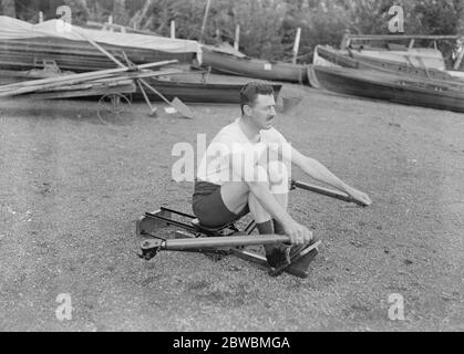 L' allenatore domestico e la macchina ginnica di Ernest Barry , il famoso sculler , hanno dato una dimostrazione della nuova macchina per allenamento e allenamento indoor che ha progettato al Green' s Boat Huse , Barnes Bridge nel London Borough di Richmond upon Thames Barry all'inizio del suo colpo sull'allenatore Indoor 20 ottobre 1921 Foto Stock