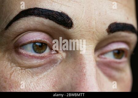 Estremo primo piano di donna mid adulta con sopracciglia dipinta. Foto Stock