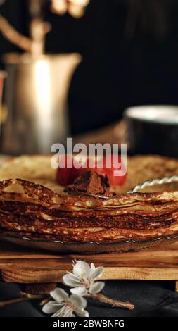 Crepes sottile, frittelle o blinis su ardesia isolato su sfondo nero, gustosa colazione Foto Stock