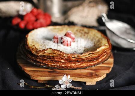 Crepes sottile, frittelle o blinis su ardesia isolato su sfondo nero, gustosa colazione Foto Stock