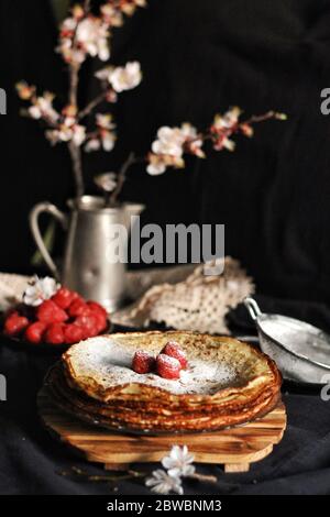 Crepes sottile, frittelle o blinis su ardesia isolato su sfondo nero, gustosa colazione Foto Stock