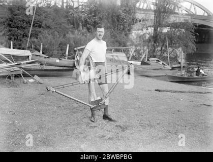 Il formatore di casa e la macchina ginnica Ernest Barry , il famoso sculler , ha dato una dimostrazione della nuova macchina per allenamento e allenamento al coperto che ha progettato al Green' s Boat Huse , Barnes Bridge nel London Borough di Richmond su Tamigi il 20 ottobre 1921 Foto Stock