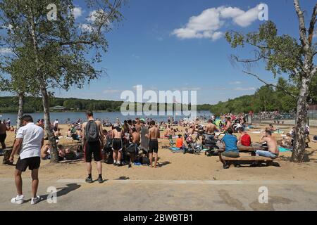 Le persone che godono del bel tempo al Ruislip Lido di Londra, come si ricorda al pubblico di praticare la distanza sociale a seguito del relax di restrizioni di blocco. Foto Stock