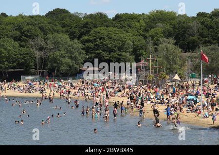 Le persone che godono del bel tempo al Ruislip Lido di Londra, come si ricorda al pubblico di praticare la distanza sociale a seguito del relax di restrizioni di blocco. Foto Stock