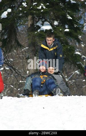 Vista panoramica di una collina innevata con famiglie con bambini e persone che slittano e divertirsi sulla neve, Parco Maksimir a Zagabria, Croazia Foto Stock