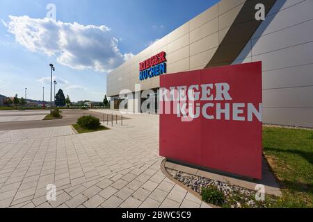 Göppingen, Germania - 21 maggio 2020: Cucine Rieger fasade, lettere blu e rosso, un sacco di luce del giorno con cielo blu nuvoloso .Goeppingen. Foto Stock