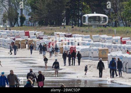 Binz, Germania. 31 maggio 2020. I turisti camminano sulla spiaggia sull'isola di Rügen. Il vivace vento del nord-est ha portato gioia a surfisti e kite surfisti. Vicino al molo i surfisti stavano aspettando le onde più alte. Escursionisti e bagnanti popolarono anche la spiaggia, che era diventata stretta a causa del vento onshore, a temperature intorno ai 15 gradi. Credit: Stefan Sauer/dpa-Zentralbild/dpa/Alamy Live News Foto Stock