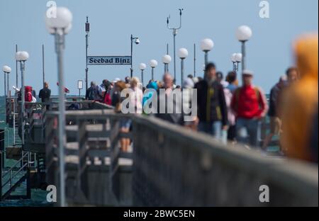 Binz, Germania. 31 maggio 2020. Gli oristi camminano attraverso il molo. Il vivace vento nord-orientale ha portato gioia ai surfisti e ai kite surfisti. Vicino al molo i surfisti stavano aspettando le onde più alte. Escursionisti e bagnanti popolarono anche la spiaggia, che era diventata stretta a causa del vento onshore, a temperature intorno ai 15 gradi. Credit: Stefan Sauer/dpa-Zentralbild/dpa/Alamy Live News Foto Stock